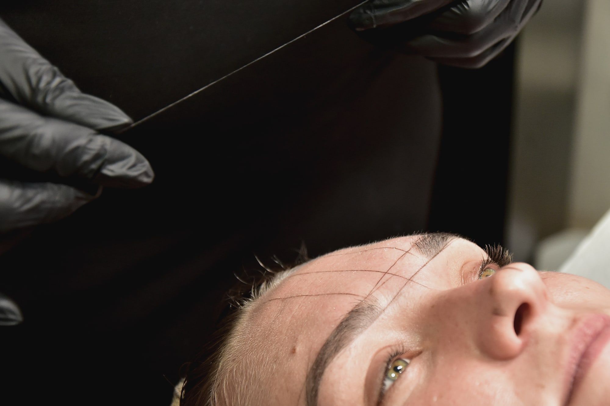 A client’s brow mapped with fine guide lines before permanent makeup.